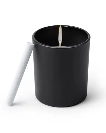 Vela aromática con olor a vainilla en recipiente cerámico negro redondo